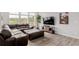 Comfortable living room with hardwood floors, brown leather sectional, and large windows at 870 Mosquito Ct, Elizabeth, CO 80107