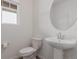 Clean powder room with pedestal sink, toilet, and a window for natural light at 870 Mosquito Ct, Elizabeth, CO 80107