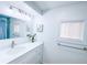 Bathroom featuring a vanity with drawers, a faucet, a mirror, and a window at 815 Plum Ave, Lochbuie, CO 80603