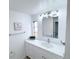 Bright bathroom with white vanity, modern lighting, framed artwork, and a large mirror at 815 Plum Ave, Lochbuie, CO 80603
