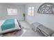 Bright bedroom with a bed, bench and two windows at 815 Plum Ave, Lochbuie, CO 80603