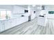 Modern kitchen featuring white cabinetry, stainless steel appliances, and light wood flooring at 815 Plum Ave, Lochbuie, CO 80603