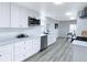 Renovated kitchen features stainless steel appliances, white cabinets, and light wood flooring at 815 Plum Ave, Lochbuie, CO 80603