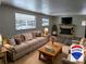 Cozy living room with a fireplace, comfortable sofa, and large windows showcasing the outdoor view at 11967 W Ranch Elsie Rd, Golden, CO 80403