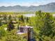 Aerial view of a multi-level home with a rooftop deck, surrounded by lush greenery and mountain views at 6843 Fairview Dr, Boulder, CO 80303