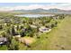 Aerial view of a home with mountain and lake views in a lush green landscape at 6843 Fairview Dr, Boulder, CO 80303