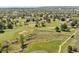 Scenic aerial view of golf course with lush green fairways surrounded by mature trees and homes at 8806 Tuscany Ln, Highlands Ranch, CO 80130