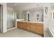 Bathroom with a double sink vanity, large mirror, and a shower behind gold framed glass doors at 8806 Tuscany Ln, Highlands Ranch, CO 80130