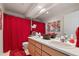 Well-lit bathroom with double sinks, modern fixtures, and a red accent curtain for privacy at 8806 Tuscany Ln, Highlands Ranch, CO 80130
