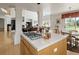 Bright kitchen with cooktop island flows into living area with high ceilings and natural light at 8806 Tuscany Ln, Highlands Ranch, CO 80130