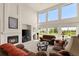 Comfortable living room with a cozy fireplace and expansive windows with golf course views at 8806 Tuscany Ln, Highlands Ranch, CO 80130