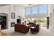 Sun-filled living room featuring a fireplace and soaring windows offering stunning views at 8806 Tuscany Ln, Highlands Ranch, CO 80130