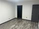 A simple bedroom features gray laminate flooring, a closet, and a dark grey door at 3081 W 18Th Ave, Denver, CO 80204