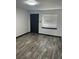 An empty bedroom features gray laminate flooring, a window, and a dark grey door at 3081 W 18Th Ave, Denver, CO 80204