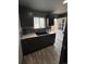 A modern kitchen featuring gray laminate flooring, gray cabinets, sink, and a back door at 3081 W 18Th Ave, Denver, CO 80204
