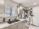 A kitchen features gray cabinets, a window, a sink, and open shelving for convenient storage at 3081 W 18Th Ave, Denver, CO 80204
