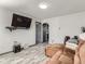 Open living room with a brown sofa and a television mounted to the wall at 3081 W 18Th Ave, Denver, CO 80204