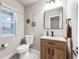 Well-lit powder room with a modern vanity, decorative wall hangings, and a neutral color palette at 2418 Coach House Loop, Castle Rock, CO 80109