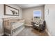 Charming Bedroom featuring a crib, cozy rocking chair, and lots of natural light at 2418 Coach House Loop, Castle Rock, CO 80109