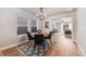 Open dining room with wood floors, large windows, and a stylish rug leading into the living room at 2418 Coach House Loop, Castle Rock, CO 80109