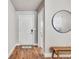 Inviting entryway with light walls, wood floors, a wooden bench, and a stylish round mirror at 2418 Coach House Loop, Castle Rock, CO 80109