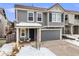 Charming gray two-story home featuring a cozy front porch, attached garage, and well-maintained landscaping at 2418 Coach House Loop, Castle Rock, CO 80109