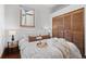 Cozy bedroom featuring a queen-size bed with white linens, wood flooring, and a window with natural light at 55 S Grant St, Denver, CO 80209