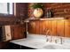 Rustic kitchen area featuring a white sink, exposed brick wall, and wood paneling, creating a warm and inviting space at 55 S Grant St, Denver, CO 80209