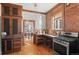 Well-lit kitchen featuring exposed brick, stainless steel appliances, and hardwood floors at 55 S Grant St, Denver, CO 80209