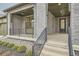 Covered front porch with gray brick exterior and black railing at 1853 Hickory Ave, Erie, CO 80516