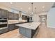 Modern kitchen with dark cabinetry, marble island, and stainless steel appliances at 1853 Hickory Ave, Erie, CO 80516