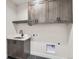 Laundry room with dark wood cabinets and sink at 1853 Hickory Ave, Erie, CO 80516