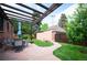 Private backyard patio featuring a dining area, mature trees, and manicured lawn for relaxed outdoor living at 2300 Jasmine St, Denver, CO 80207