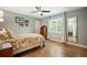 Bright bedroom featuring a ceiling fan, large window and hardwood floors at 2300 Jasmine St, Denver, CO 80207