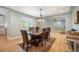 Dining area with a solid wooden table, decorative chandelier, and a view through to the kitchen at 2300 Jasmine St, Denver, CO 80207