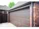 Close-up of a modern brown garage door with brick siding at 2300 Jasmine St, Denver, CO 80207