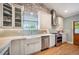 Bright kitchen featuring a farmhouse sink, stainless steel appliances, and a brick accent wall at 2300 Jasmine St, Denver, CO 80207