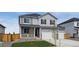 Charming two-story home features a three car garage, a cozy front porch, and an inviting exterior, with gray siding at 4211 Sandstone Dr, Mead, CO 80504
