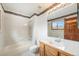 Bathroom with tile flooring, shower-over-tub and wood vanity, combining functionality with traditional style at 15846 W Bayaud Dr, Golden, CO 80401