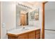 Bright bathroom featuring wooden vanity, countertop, large mirror, and modern lighting at 15846 W Bayaud Dr, Golden, CO 80401