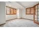 Bright bedroom featuring grey carpet, natural wood trim, shutters, and plenty of natural light at 15846 W Bayaud Dr, Golden, CO 80401