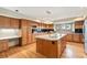 Spacious kitchen featuring wood cabinets, granite counters, and an island with a double sink at 15846 W Bayaud Dr, Golden, CO 80401