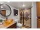 Modern bathroom featuring glass bowl sink, framed mirror, and elegant tile surround in the shower at 13404 E Jewell Ave # 101, Aurora, CO 80012