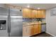Kitchen features stainless steel appliances, light wood cabinetry, mosaic backsplash, granite countertops and dark flooring at 13404 E Jewell Ave # 101, Aurora, CO 80012