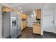 Well-lit kitchen boasts stainless steel fridge, light wood cabinets, mosaic backsplash, dark flooring, and modern appliances at 13404 E Jewell Ave # 101, Aurora, CO 80012