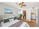 Cozy bedroom with ceiling fan, ensuite bath/laundry room, neutral decor, and natural light from window at 13404 E Jewell Ave # 101, Aurora, CO 80012