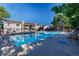 Community swimming pool surrounded by lounge chairs and mature trees at 13404 E Jewell Ave # 101, Aurora, CO 80012