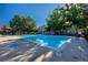 Community swimming pool surrounded by lounge chairs and mature trees at 13404 E Jewell Ave # 101, Aurora, CO 80012