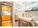 This bathroom features a wood vanity, a modern sink, tile backsplash, and a doorway view to the kitchen at 1365 N Corona St # 11, Denver, CO 80218