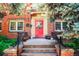 Charming red brick condo entrance with a vibrant red door, surrounded by lush greenery and decorative plants at 1365 N Corona St # 11, Denver, CO 80218